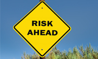 Photo showing a yellow yield sign with the words “Risk Ahead.”