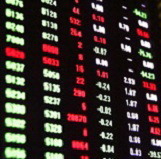 Stock prices reported on a black reporting board